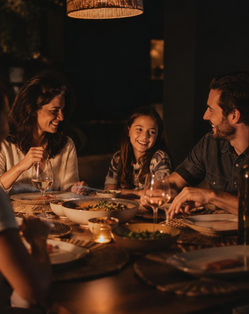 Family sharing dinner by candlelight